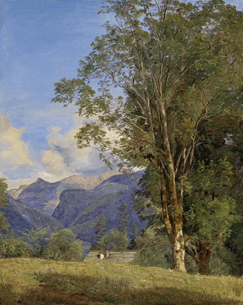 A large tree stands in the foreground of a sunlit meadow with two small figures in the distance; behind it are lush green hills, forests and high blue mountains under a sky with white clouds.