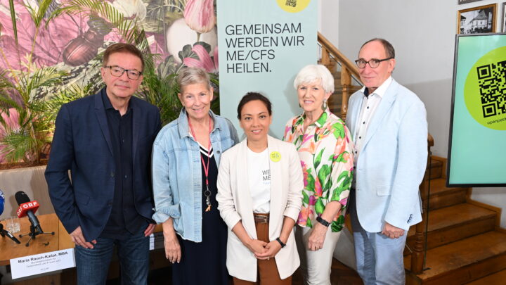 Fünf Personen stehen bei einer Presseveranstaltung zum Thema ME/CFS in Österreich gemeinsam in einem Raum: Vier ehemalige Minister unterstützen die Petition zum PAIS-Aktionsplan. Hinter ihnen ist ein grünes Transparent mit der Aufschrift „Gemeinsam werden wir ME/CFS heilen“ zu sehen, auf dem auch ein QR-Code zu erkennen ist.