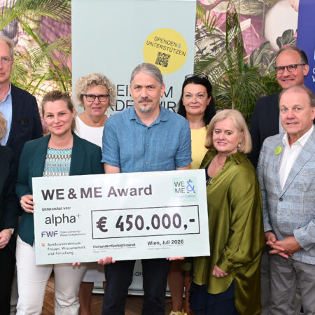 Nine people are standing together at Ströck Feierabend on Burggasse, smiling and posing with a large check for over 450,000 € for the “WE&ME Award” to benefit ME/CFS, surrounded by WE & ME and FWF banners. From left to right: Minister of Science Eva-Maria Holzleitner, Oswald Wagner (MedUni Vienna), Kathryn Hoffmann (MedUni Vienna), Sabine Seidler (alpha+ Foundation), Matthias Wielscher (MedUni Vienna), Ursula Jakubek (FWF), Gabriele and Gerhard Ströck (WE&ME Foundation), Christoph Binder (FWF).